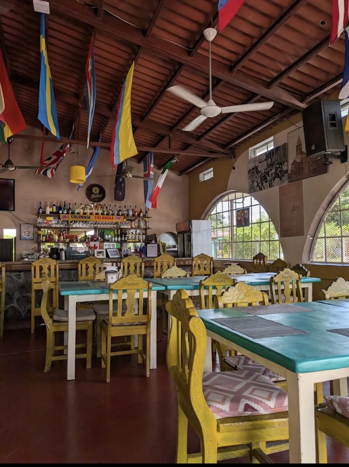 El comedor de Resto Bar Hawaii, con las sillas talladas «La Ruina» y las banderas del mundo